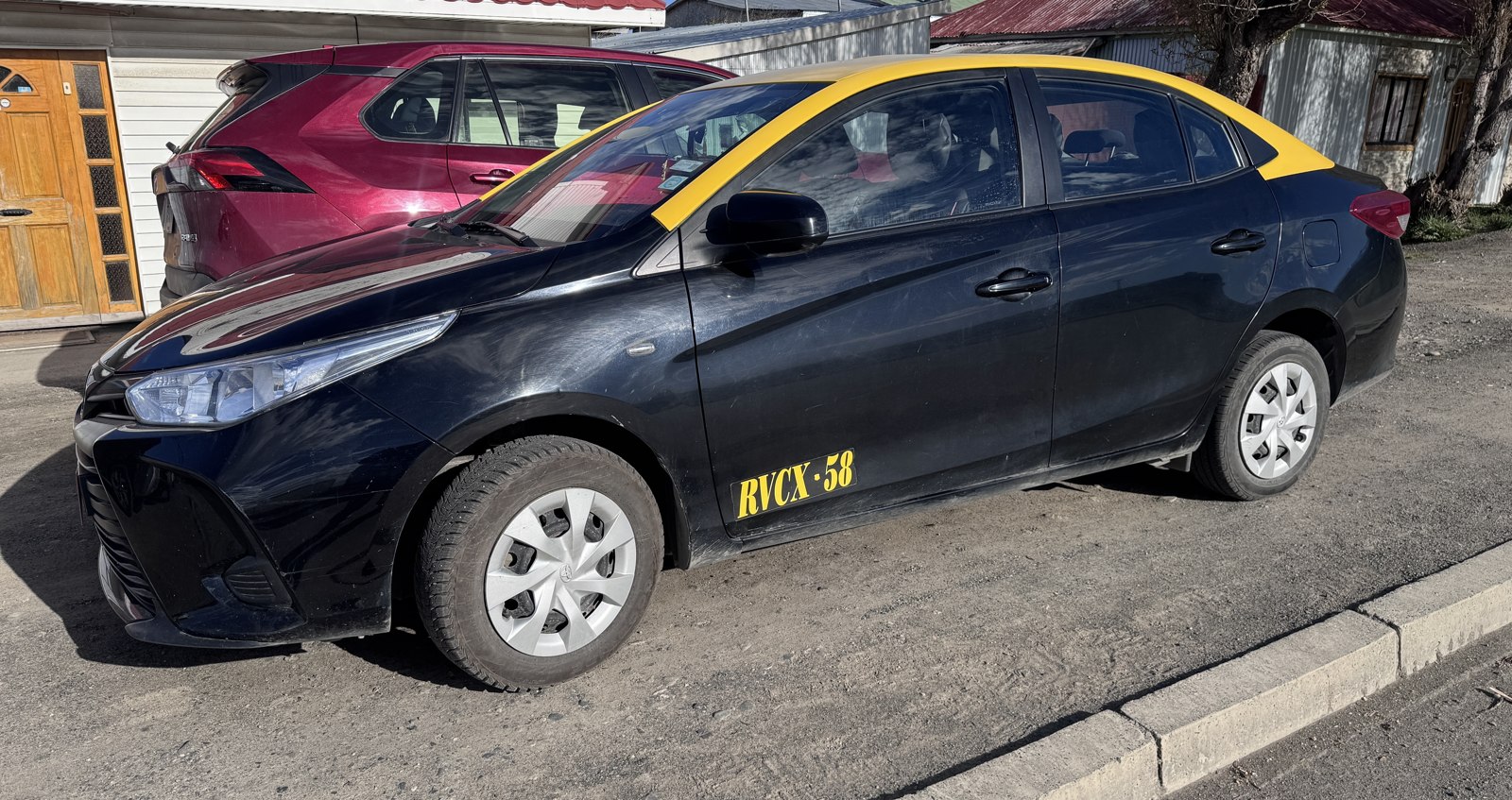 Taxi Toyota Yaris Sedán negro con techo amarillo